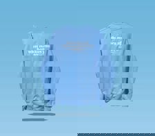 The back side of a Happy V Crewneck Sweatshirt in blue with a sentence on the shirt saying "do more of what makes you happy" against a blue background.